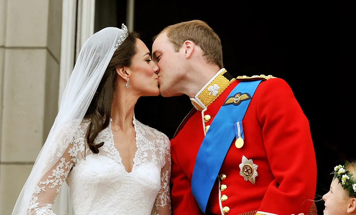 Kate Middleton and Prince William kiss on the balcony of Buckingham Palace after getting married