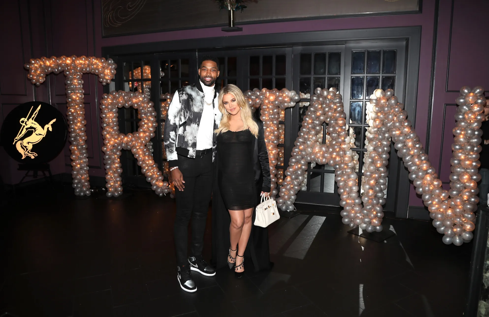 Tristan Thompson and Khloe Kardashian posing outside at night for Beauty & Essex in 2018