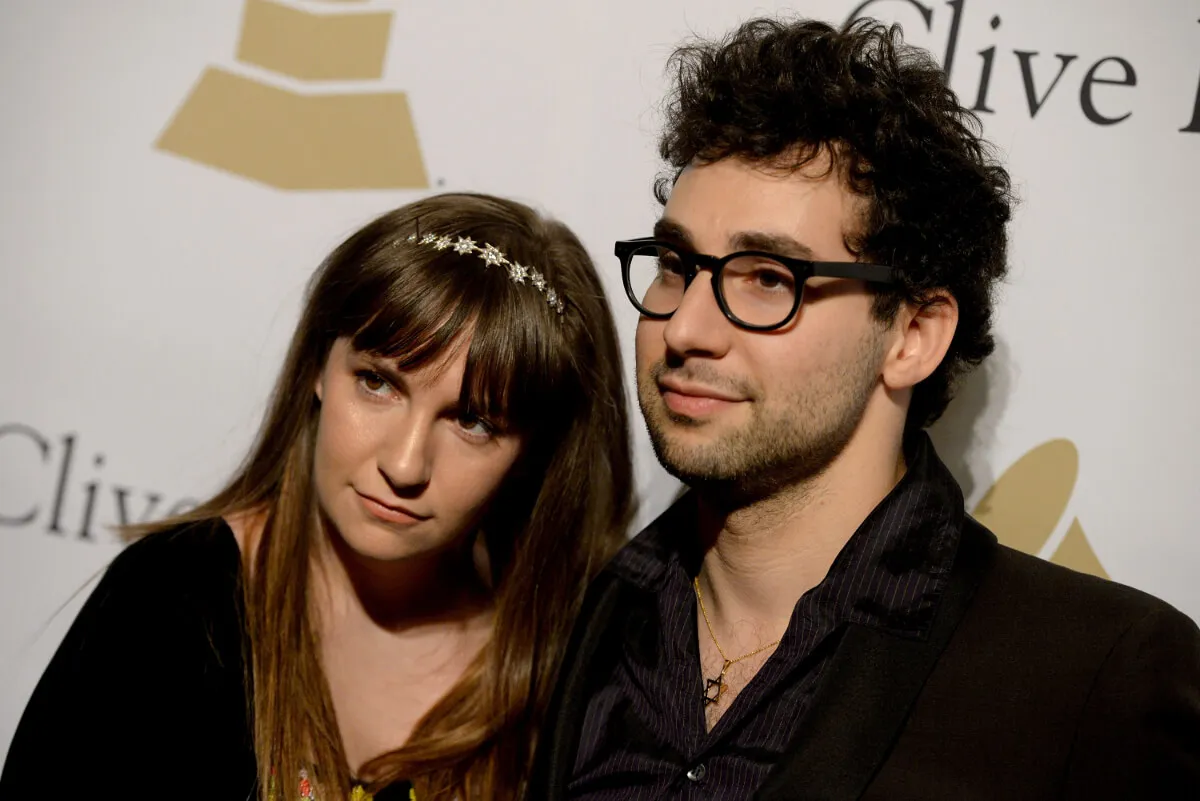Lena Dunham wears a headband and stands with Jack Antonoff. They both wear black.