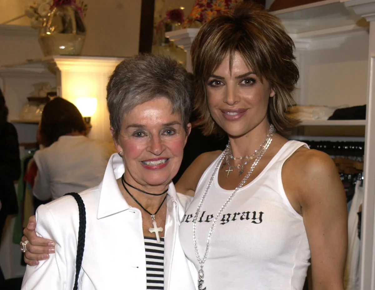 Lisa Rinna wears a white tank top and stands with her arm around her mother's shoulders. Her mother wears a striped shirt and white jacket.