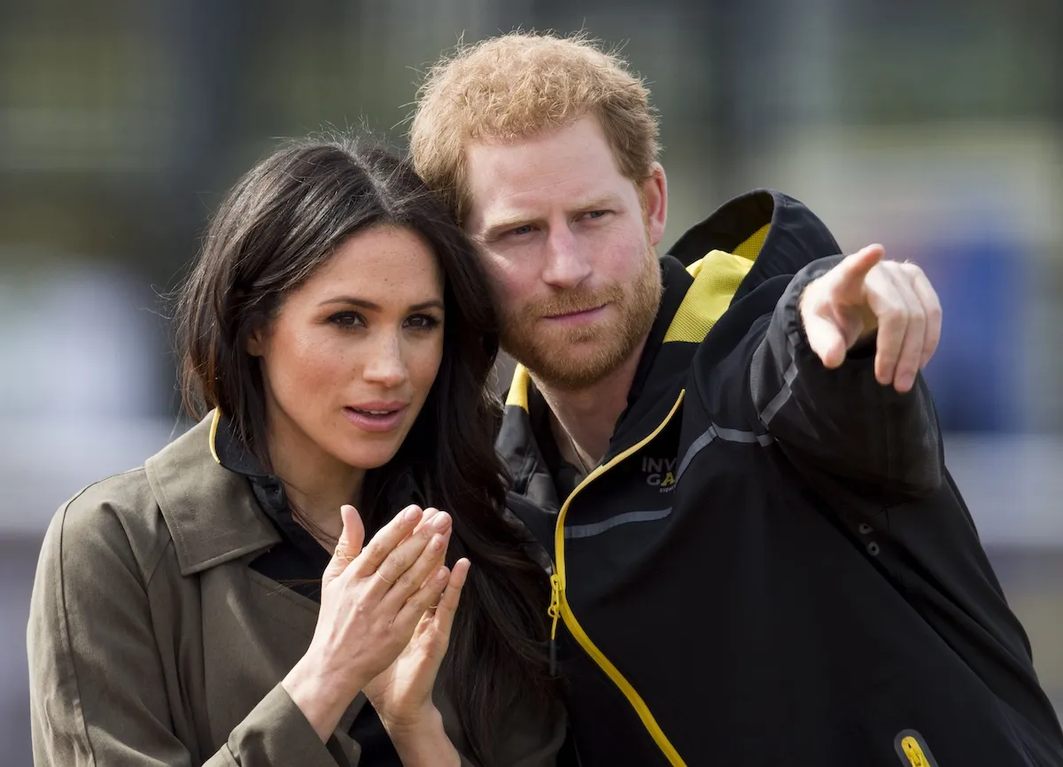 Prince Harry points something out to Meghan Markle during their 2018 tour of Australia