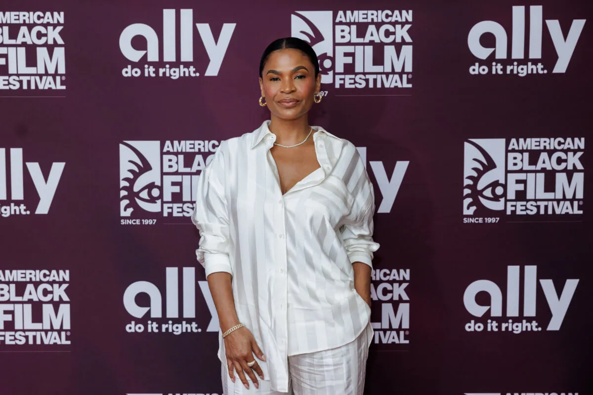 Nia Long wears a white shirt and matching white pants.