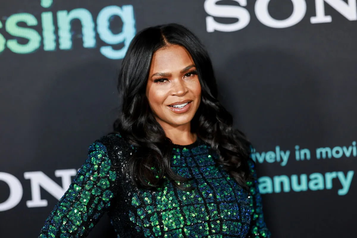 Nia Long wears a sequined dress and stands with her hand on her hip.