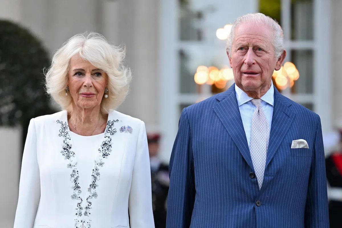 Queen Camilla, in white, and King Charles III, in a blue suit