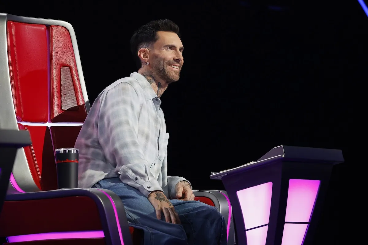 'The Voice' Season 29 coach Adam Levine smiling and sitting in the red chair