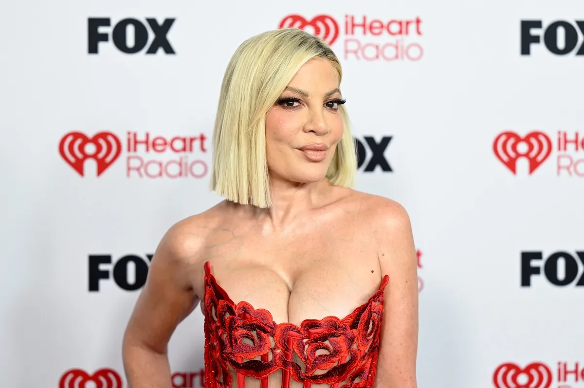 Tori Spelling in a strapless red dress and with blonde hair