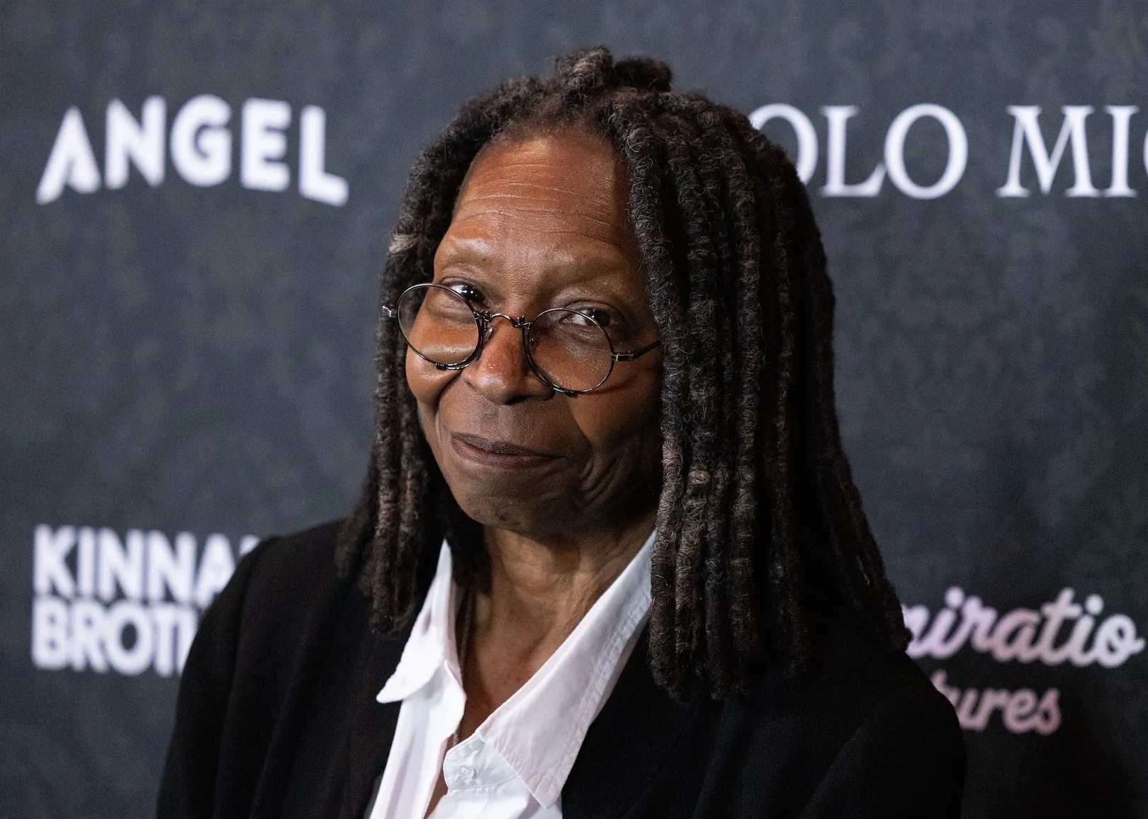 Whoopi Goldberg smirking at the camera in 2026