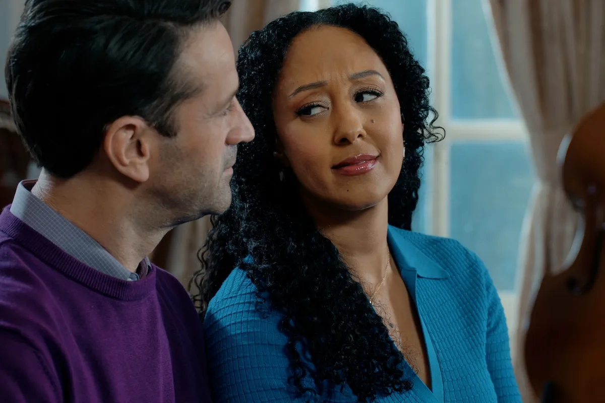 Woman with dark hair side-eyeing a man