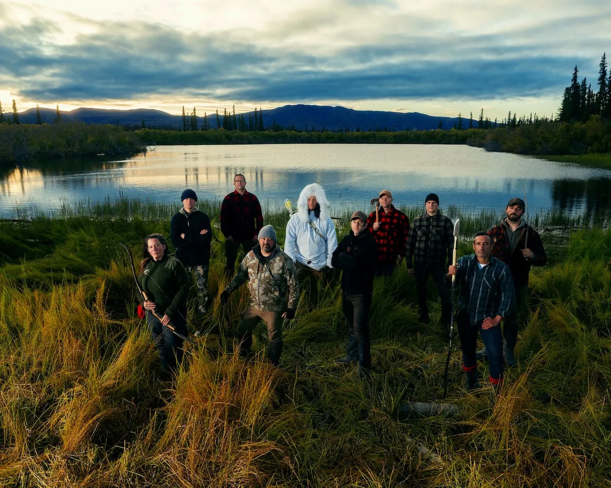 Group photo of the 'Alone' Season 13 cast standing in front of a lake