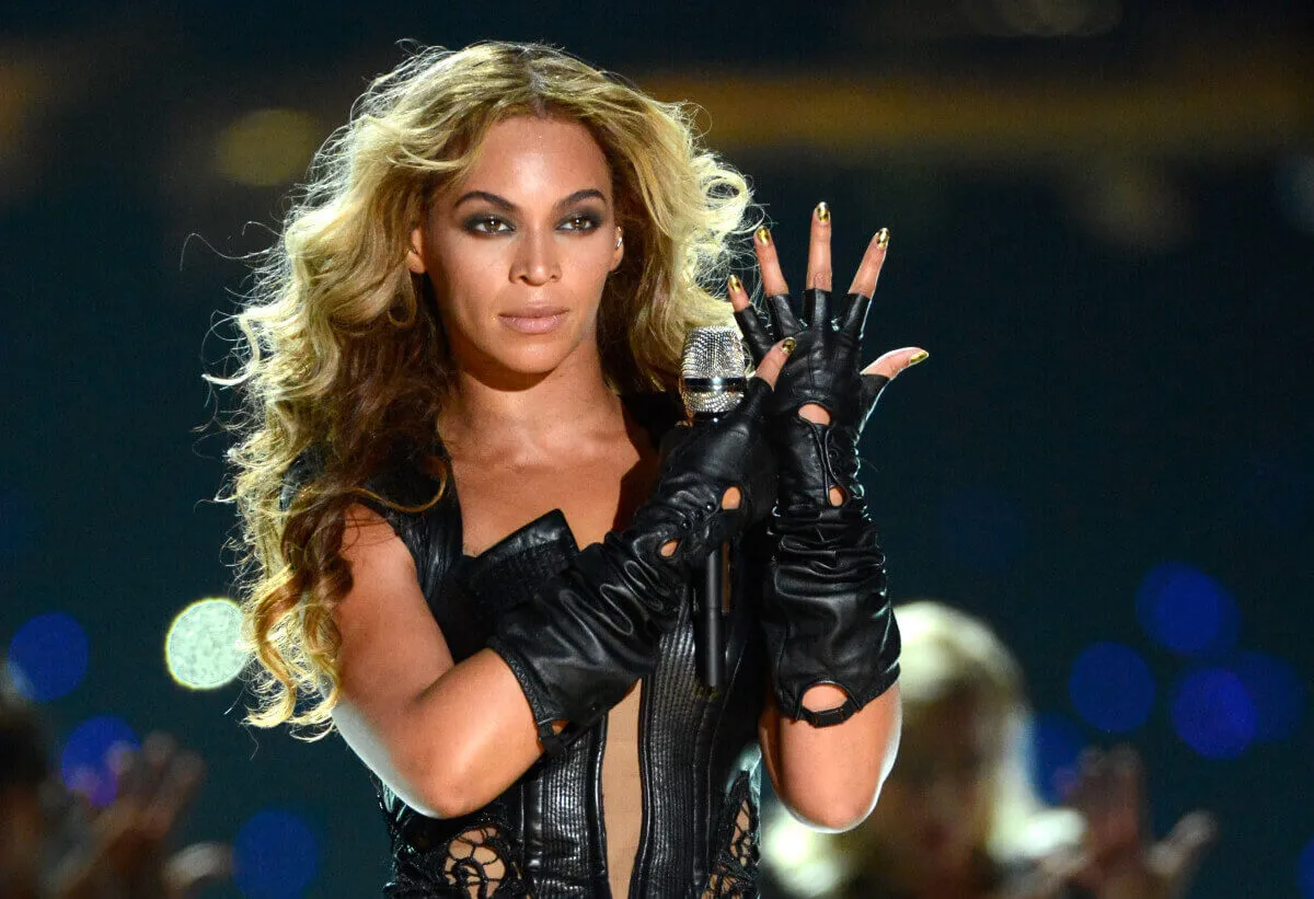 Beyonce wears a black body suit and points to her ring finger while performing 'Single Ladies.' She wears black gloves.
