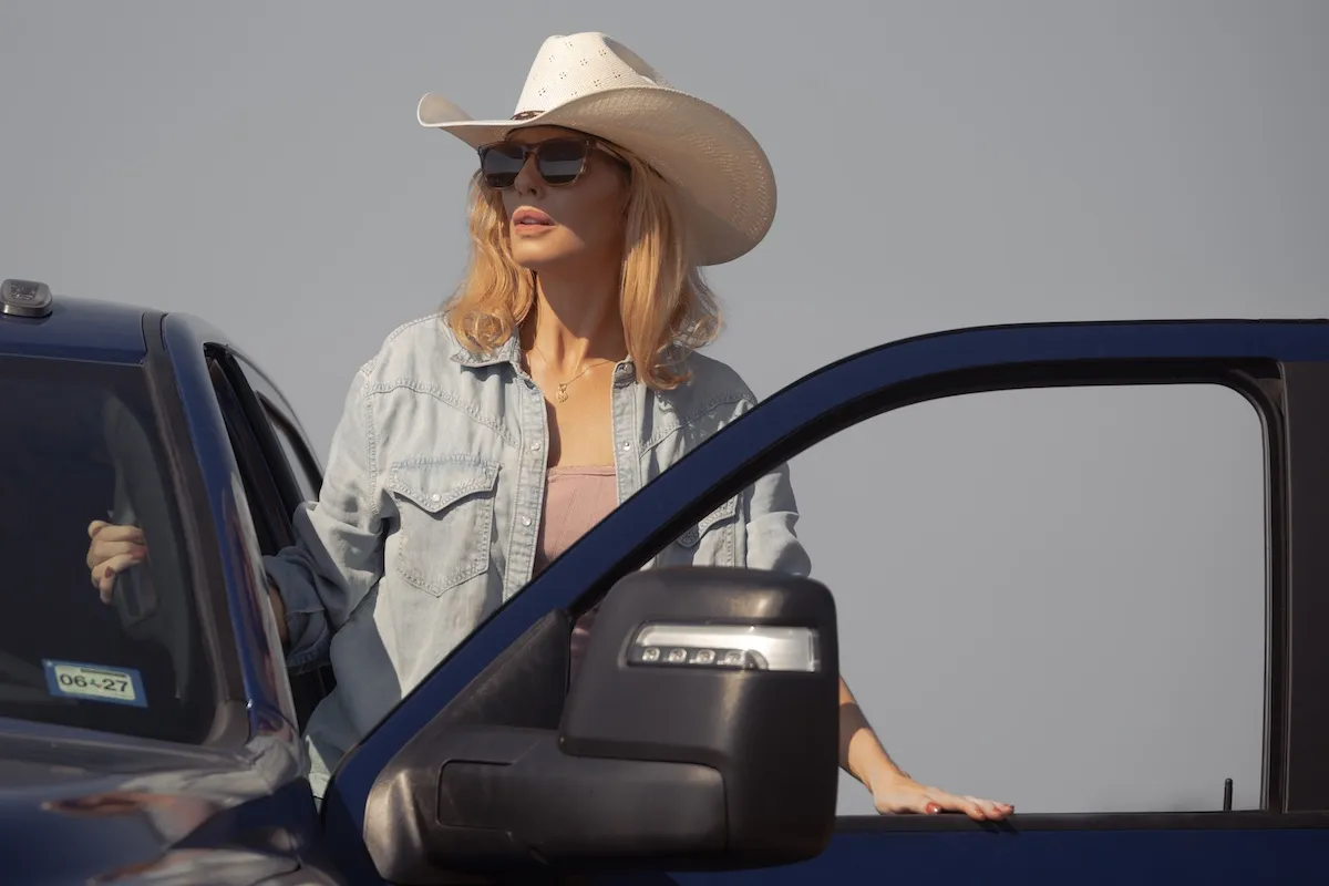 Beth Dutton (Kelly Reilly) wearing a cowboy hat and sunglasses and stepping out of a truck in 'Dutton Ranch'