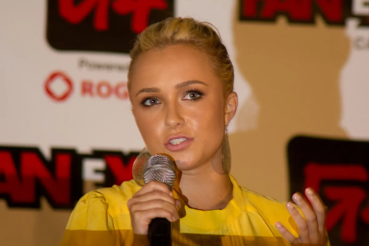 Hayden Panettiere wears a yellow shirt and talks into a microphone.