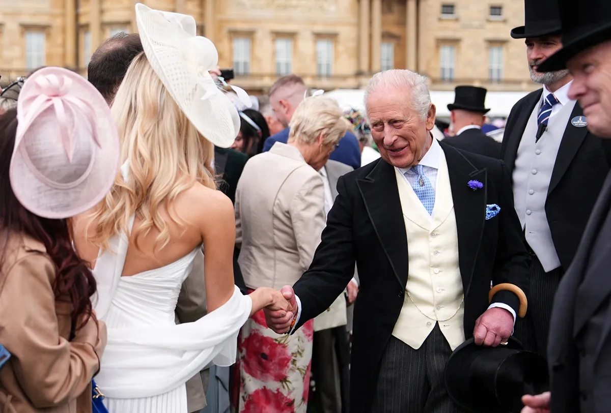 King Charles III talks to guests during a Royal Garden Party at Buckingham Palace