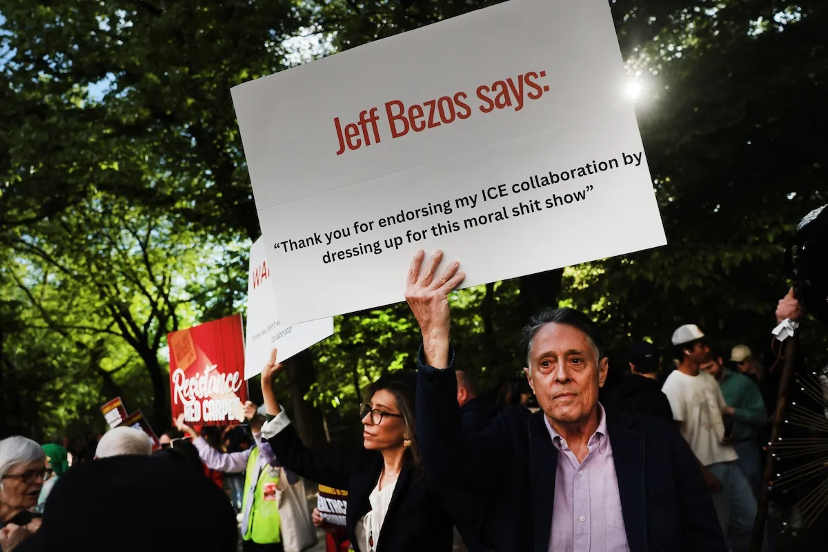 A protestor holds up a sign criticizing Jeff Bezos and the Met Gala