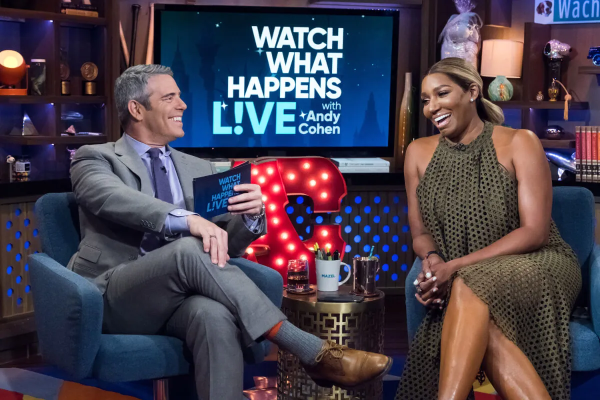 Andy Cohen wears a suit and sits next to NeNe Leakes on 'Watch What Happens Live.' She wears a brown dress.