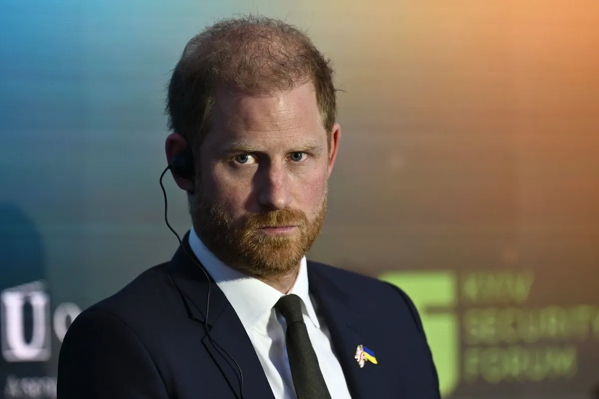 Prince Harry, looking serious and wearing a suit