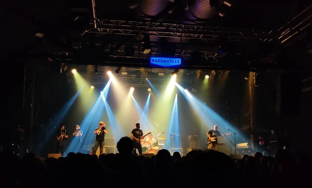 Lights shine on a stage during a concert.