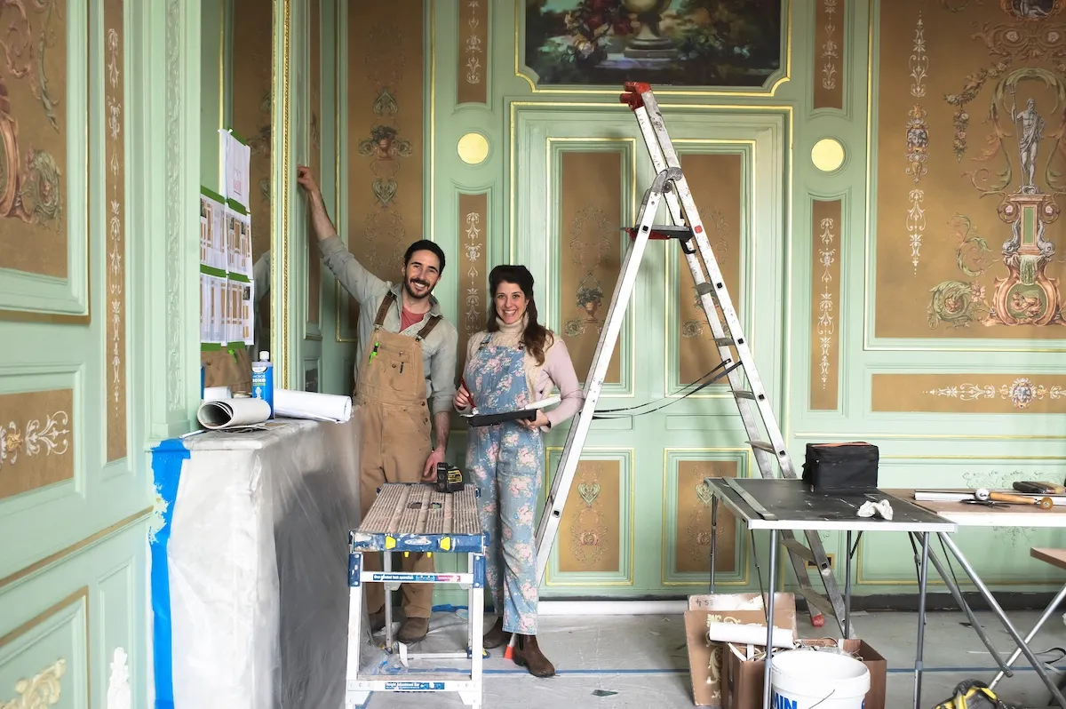 Daphne and Ian Fig of 'Castle Impossible' standing next to a ladder in their chateau