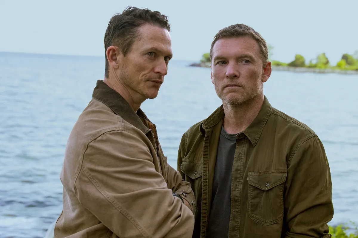 Two men standing in front of a body of water in Netflix's 'I Will Find You'