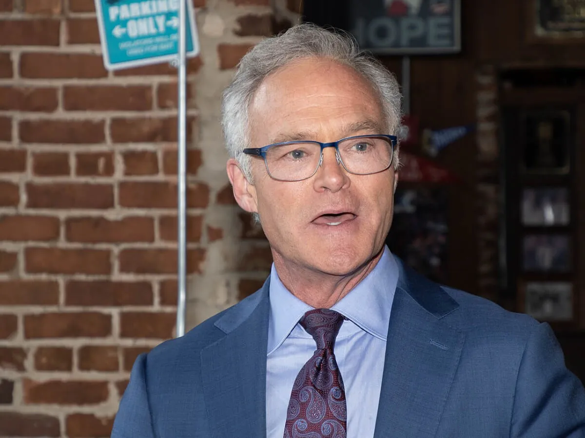 Scott Pelley wears a blue suit and glasses.