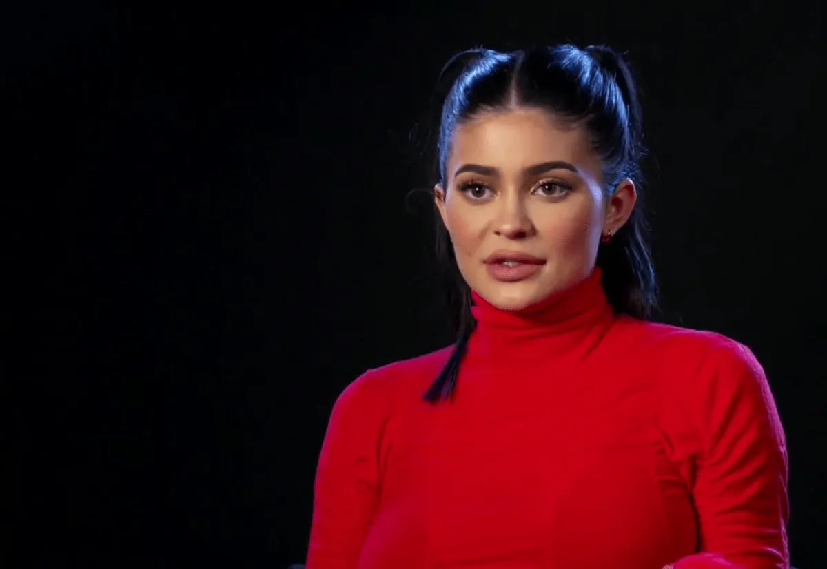 Kylie Jenner wears a red turtleneck.