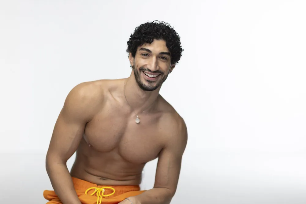 Zach from Love Island wears an orange bathing suit.