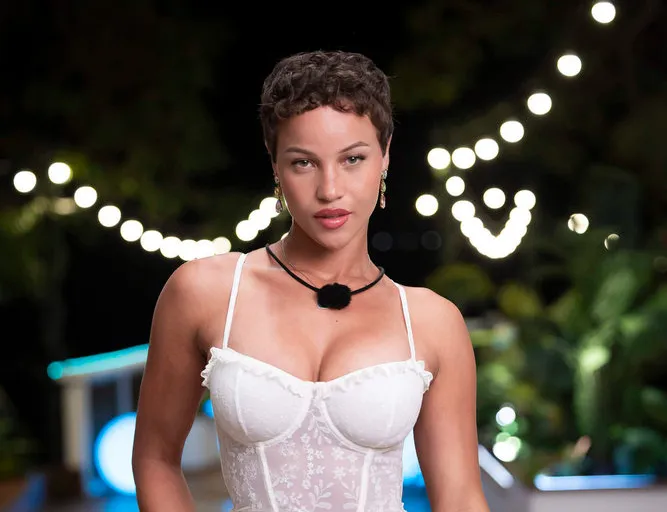 Sol Dean wears a white shirt and black necklace.