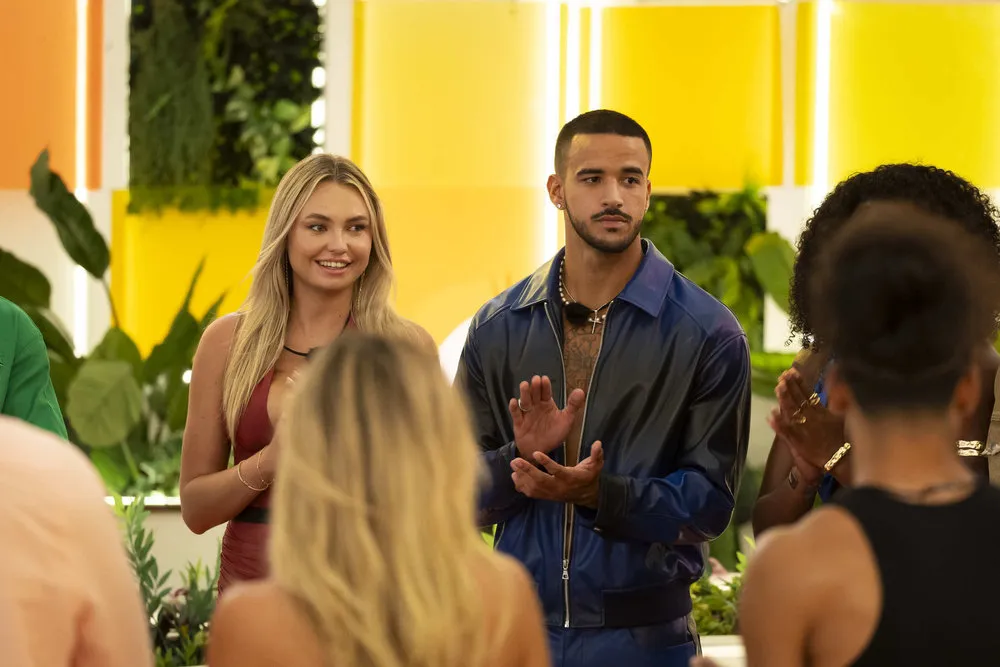 Jen and Caleb clap and stand next to each other.