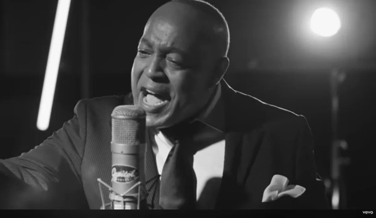 Black and white screenshot of Peabo Bryson singing