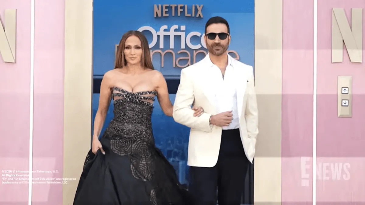 Screenshot of Jennifer Lopez and Brett Goldstein promoting Netflix movie 'Office Romance'