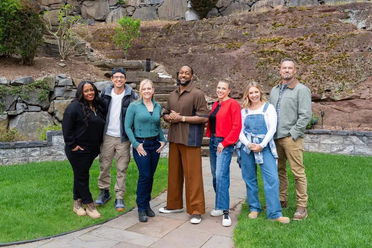 Cast of HGTV's 'Totally '90s House' standing in front of a brick wall