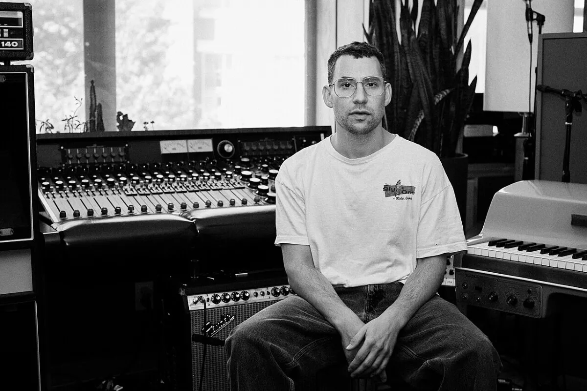 A black and white picture of Jack Antonoff sitting in a studio.