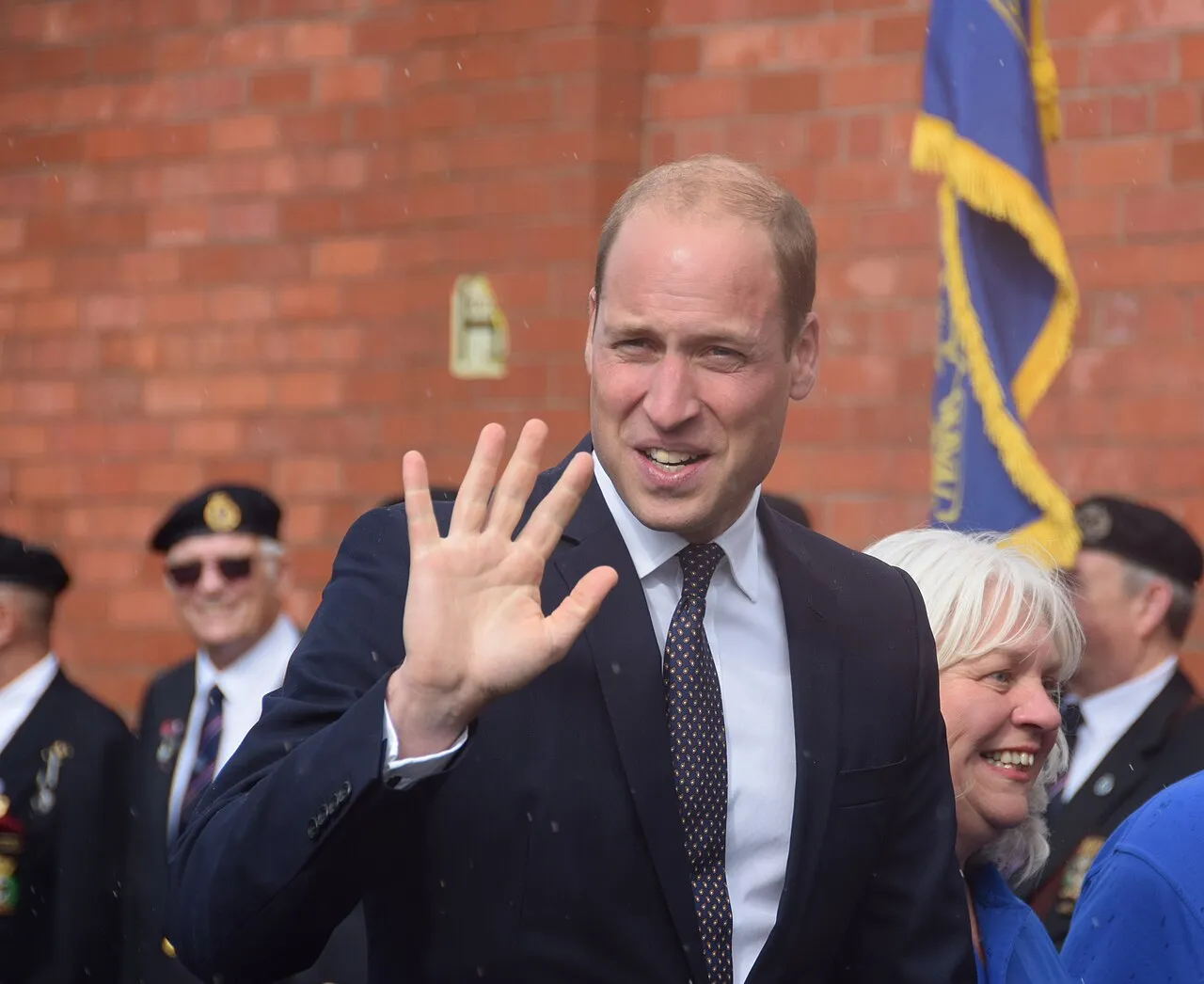 Prince William waving to a crowd