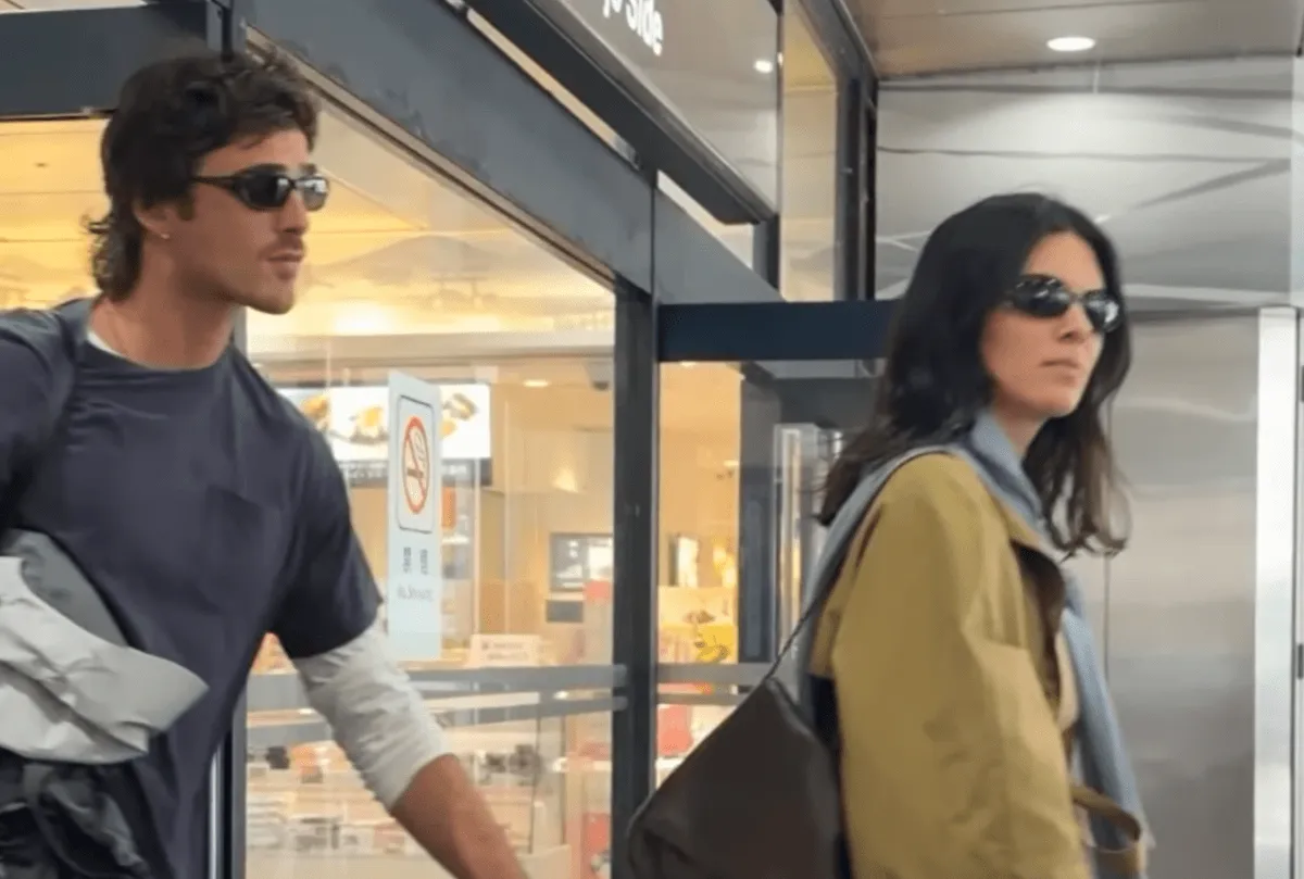 Jacob Elordi and Kendall Jenner wear sunglasses. They hold hands as they walk.