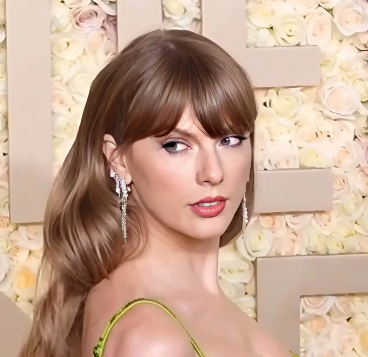 Taylor Swift wears a green dress and looks over her shoulder.