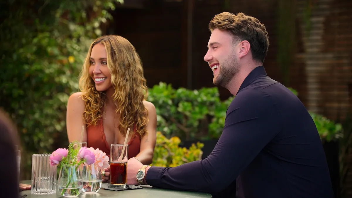 Smiling Amber Mozo sitting next to Harry Jowsey in 'Let's Marry Harry'