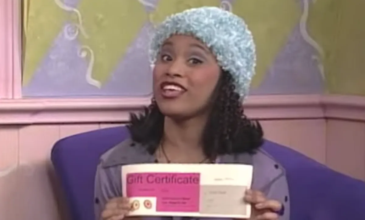 Christy Knowings holding up a gift certificate in 'All That'