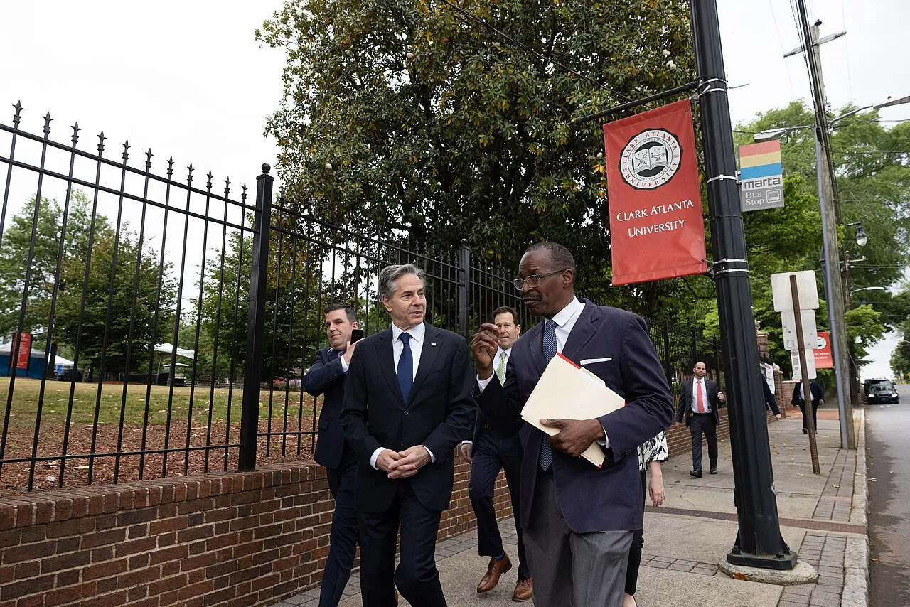 Secretary of State Anthony Blinken walking with a student on the campus of Clark Atlanta University