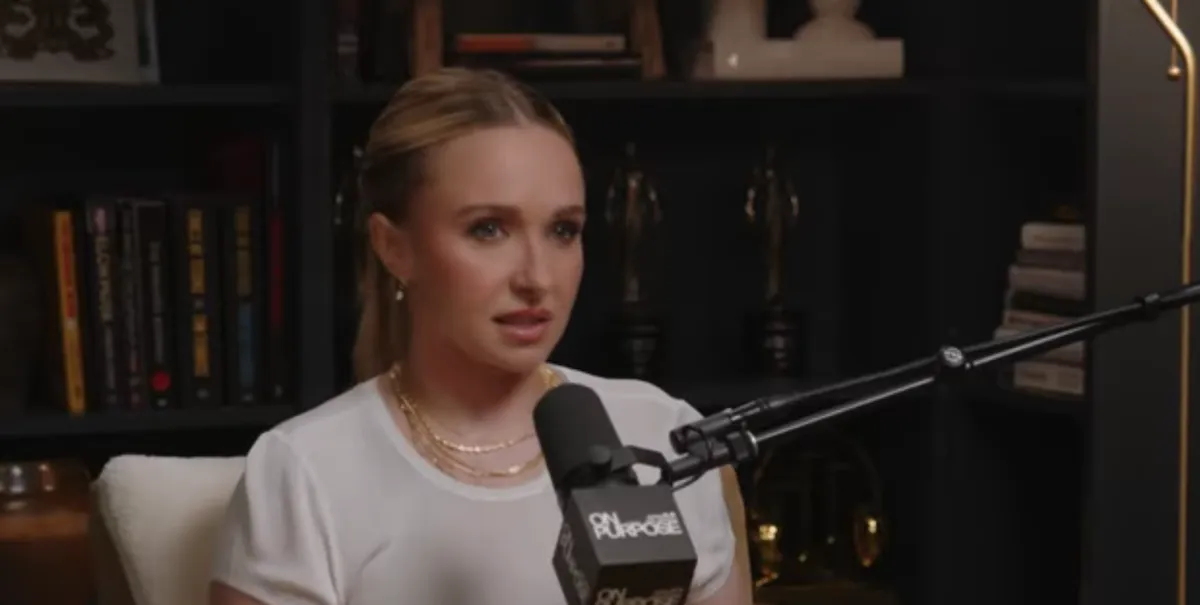 Hayden Panettiere wearing a white shirt and speaking into a microphone