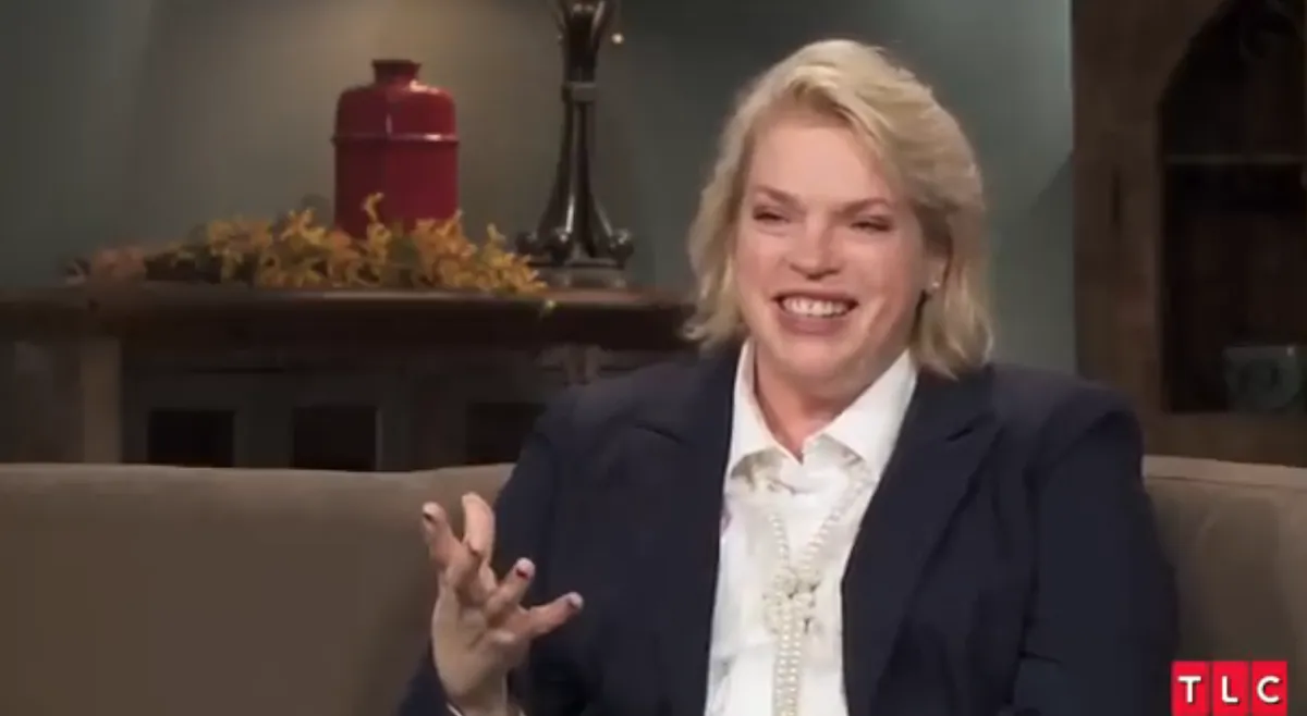 Smiling Janelle Brown wearing a blue blazer during a 'Sister Wives' interview segment