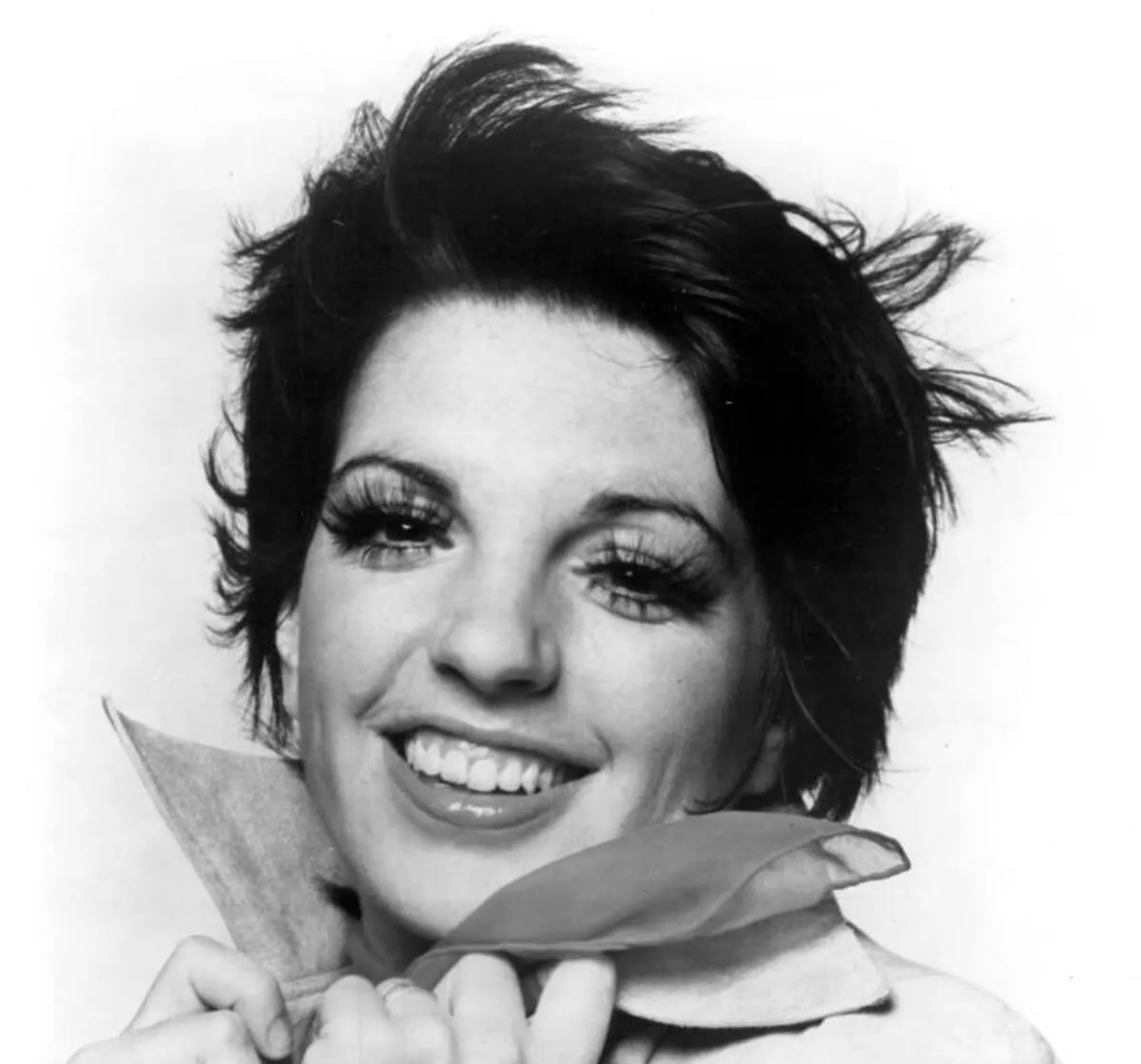 A black and white picture of Liza Minnelli holding her collar.