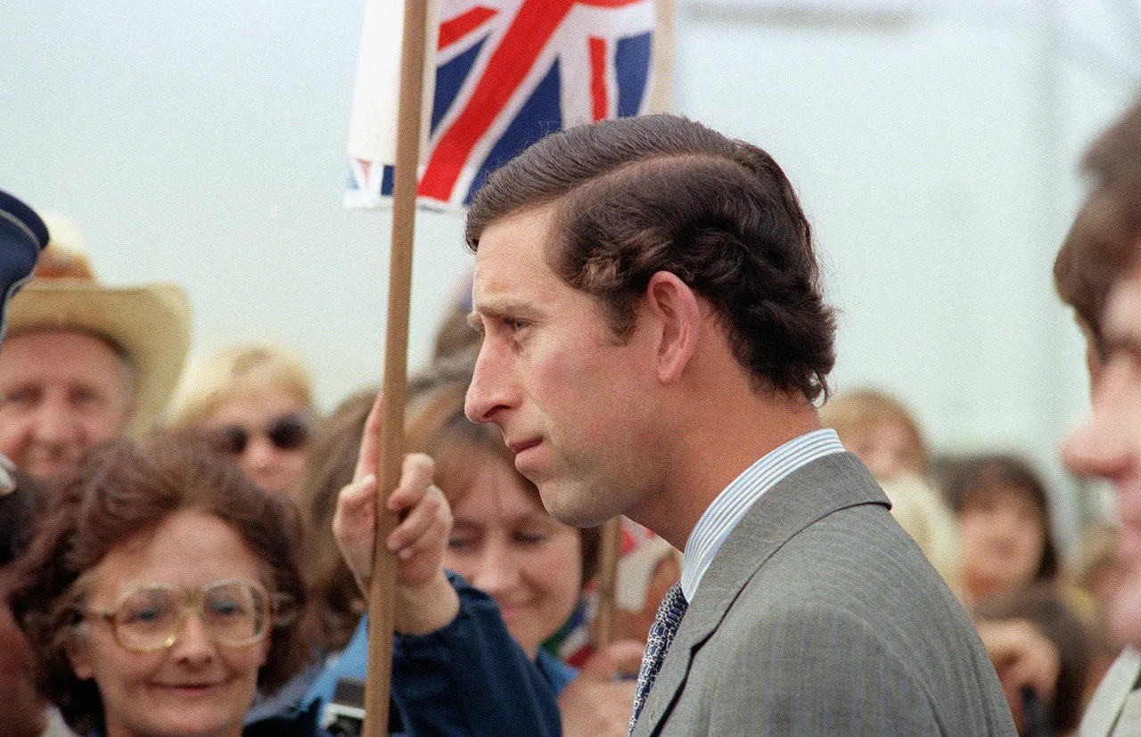 Prince Charles in profile with Union Jack in background as he arrives at Andrews Air Force Base in 1981
