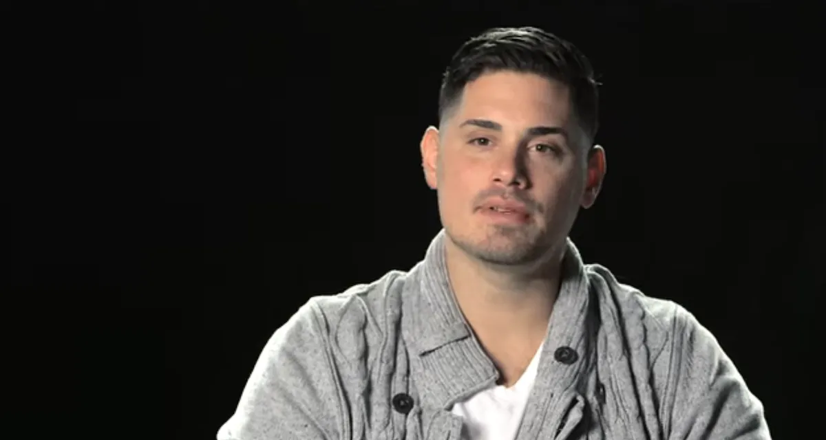 Ryan De Nino in a gray sweater againt a black background in 'Married at First Sight' Season 2