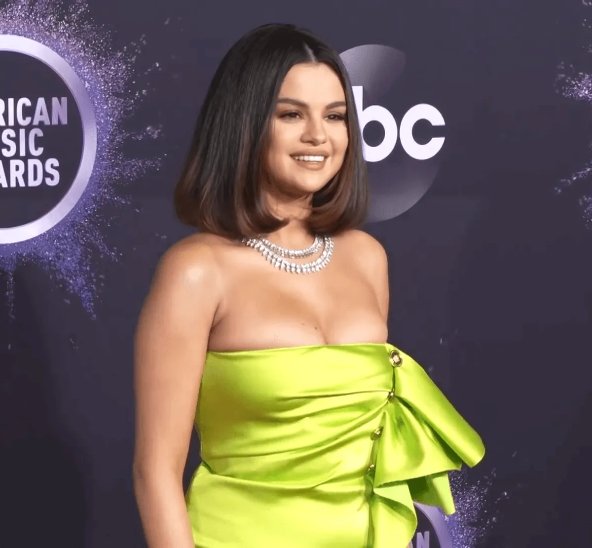Selena Gomez wears a strapless green dress and a necklace.