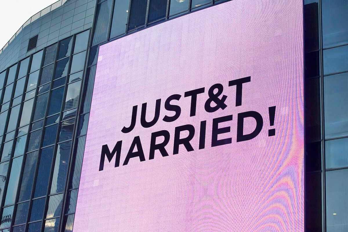 An electronic sign that reads 'JUST&T MARRIED!' outside Taylor Swift and Travis Kelce's wedding.