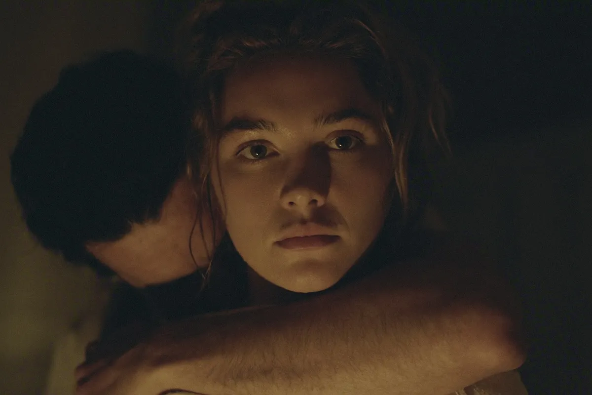Close up of Florence Pugh in East of Eden with a man holding her from behind