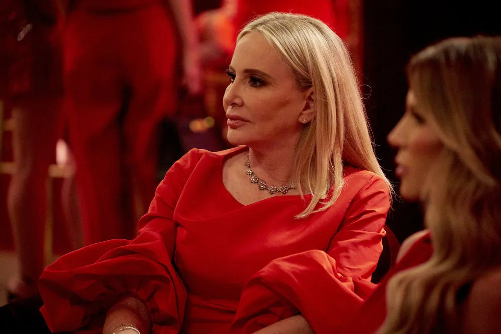 Shannon Beador wears a red dress and sits.