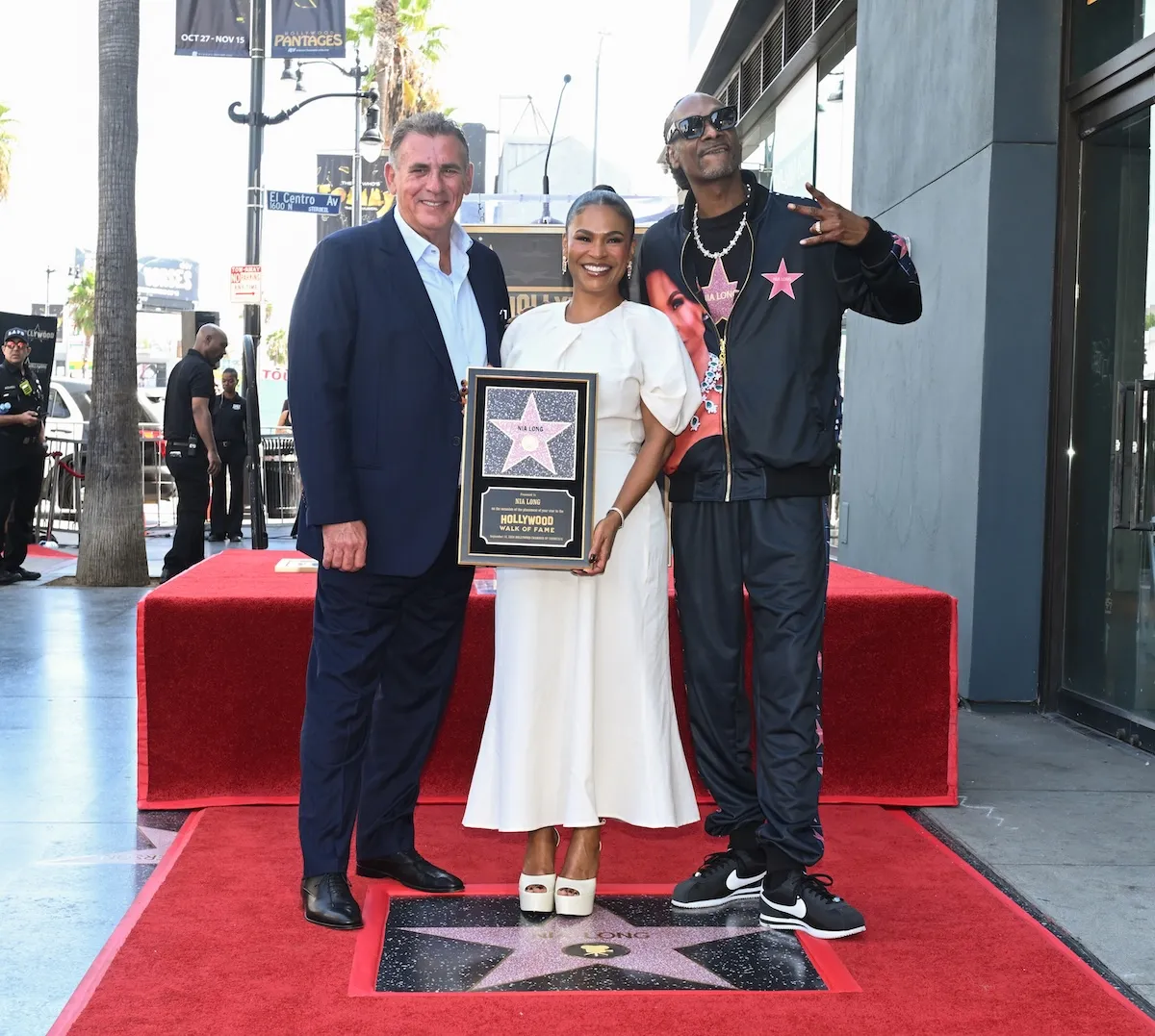 Nia Long, holding her plaque, on the Hollywood Walk of Fame, with Graham King and Snoop Dogg