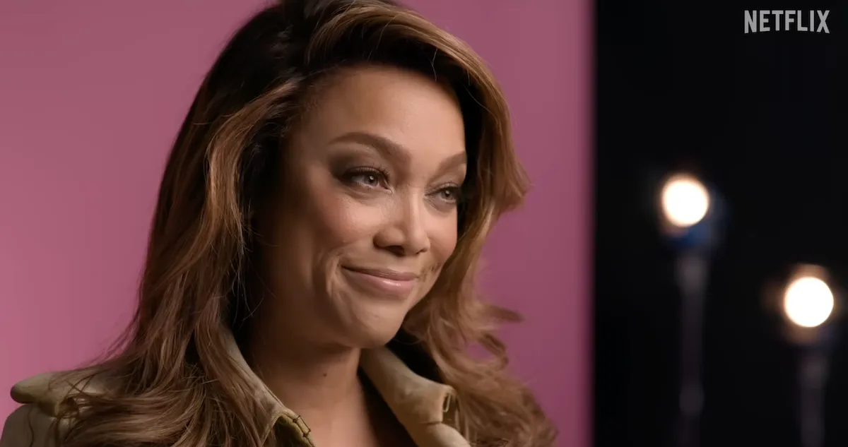 Close up of a smirking Tyra Banks in 'Reality Check: Inside America's Next Top Model' on Netflix