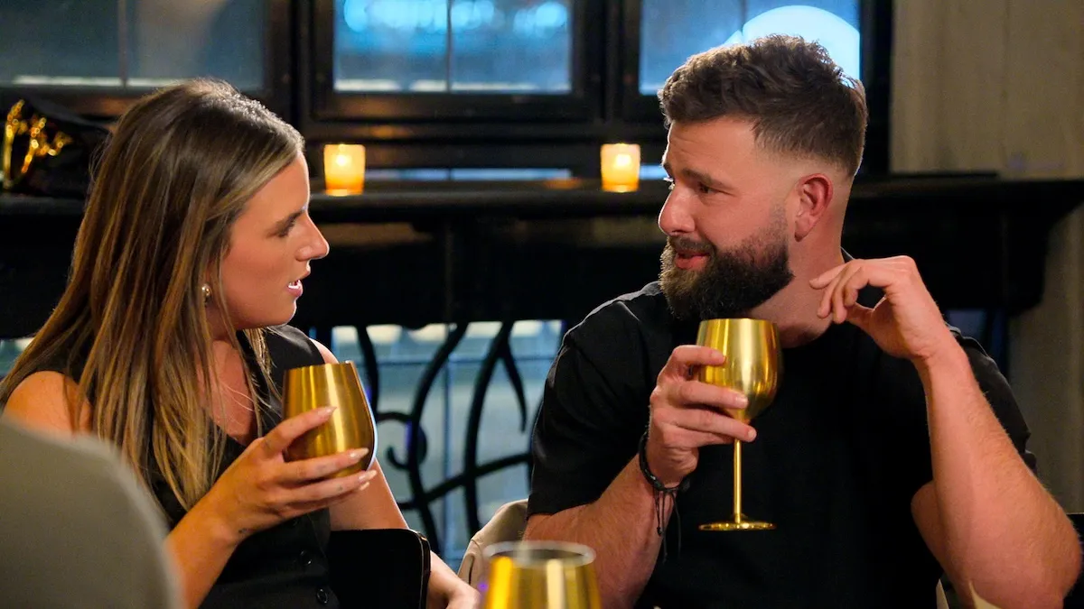 Michaella and Rob from Love Is Blind Season 11 looking at each other while holding gold goblets